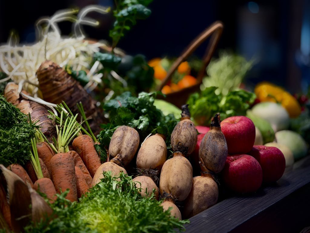 A vibrant display of fresh vegetables and fruits including carrots, apples, and greens.